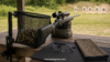 Mesh brass catcher collecting spent cases on a shooting range bench