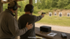Shooter practicing non-dominant-hand fundamentals safely at an outdoor range with instructor supervision