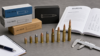 Different firearm cartridges arranged safely with a manual to explain gun caliber and ammunition matching