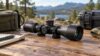 Compact black telescopic optic on a wooden outdoor workbench